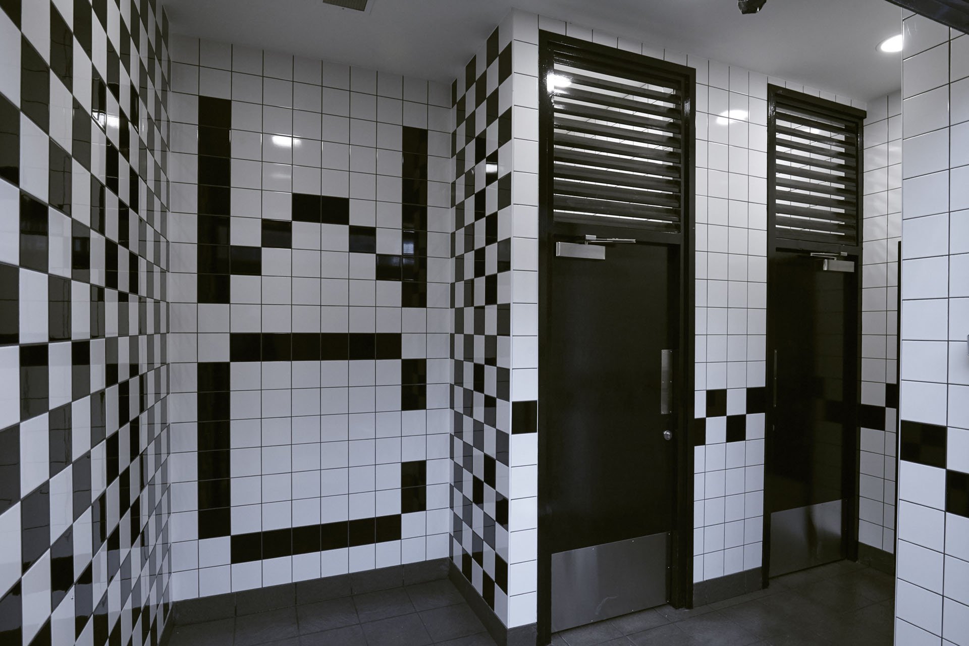 entrance doors and a WC tiling feature wall at at washroom in coventry bus station.jpg