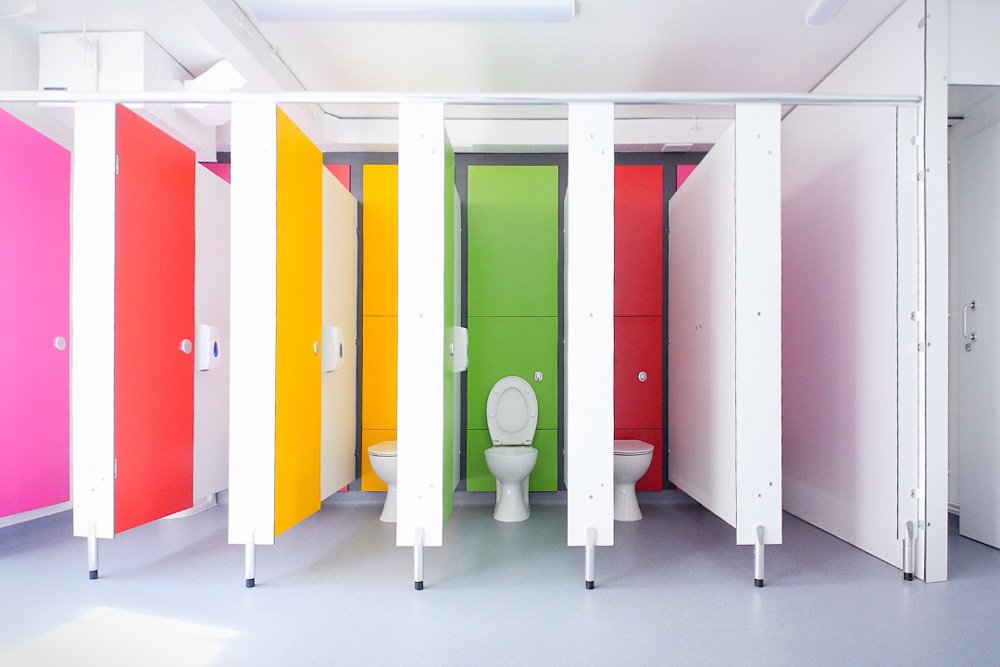 multicoloured cubicles in a washroom at lycee francais.jpg