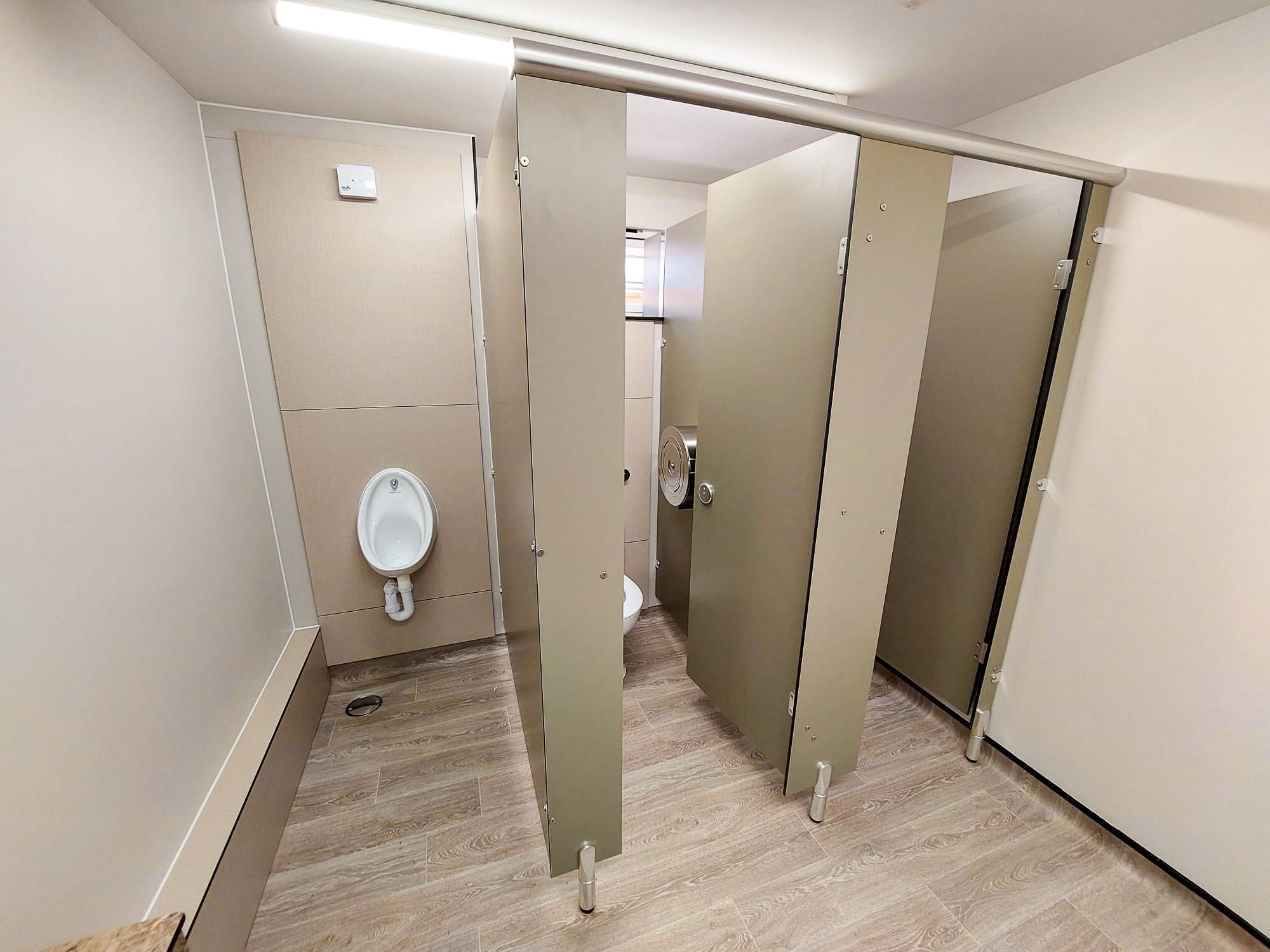 male toilet with woodgrain vinyl floor, full height urinal duct and half height ducting in toilet cubicles, all in a bespoke green colour at howletts zoo.jpg
