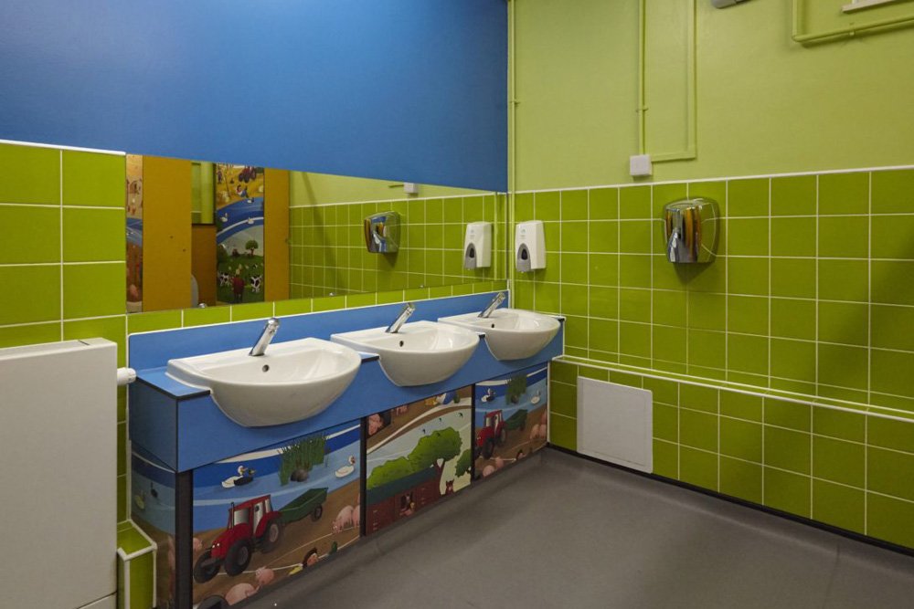 farmyard friends print vanity unit in a child washroom with sinks, soft touch taps and a mirror above at harris academy philip lane.jpg