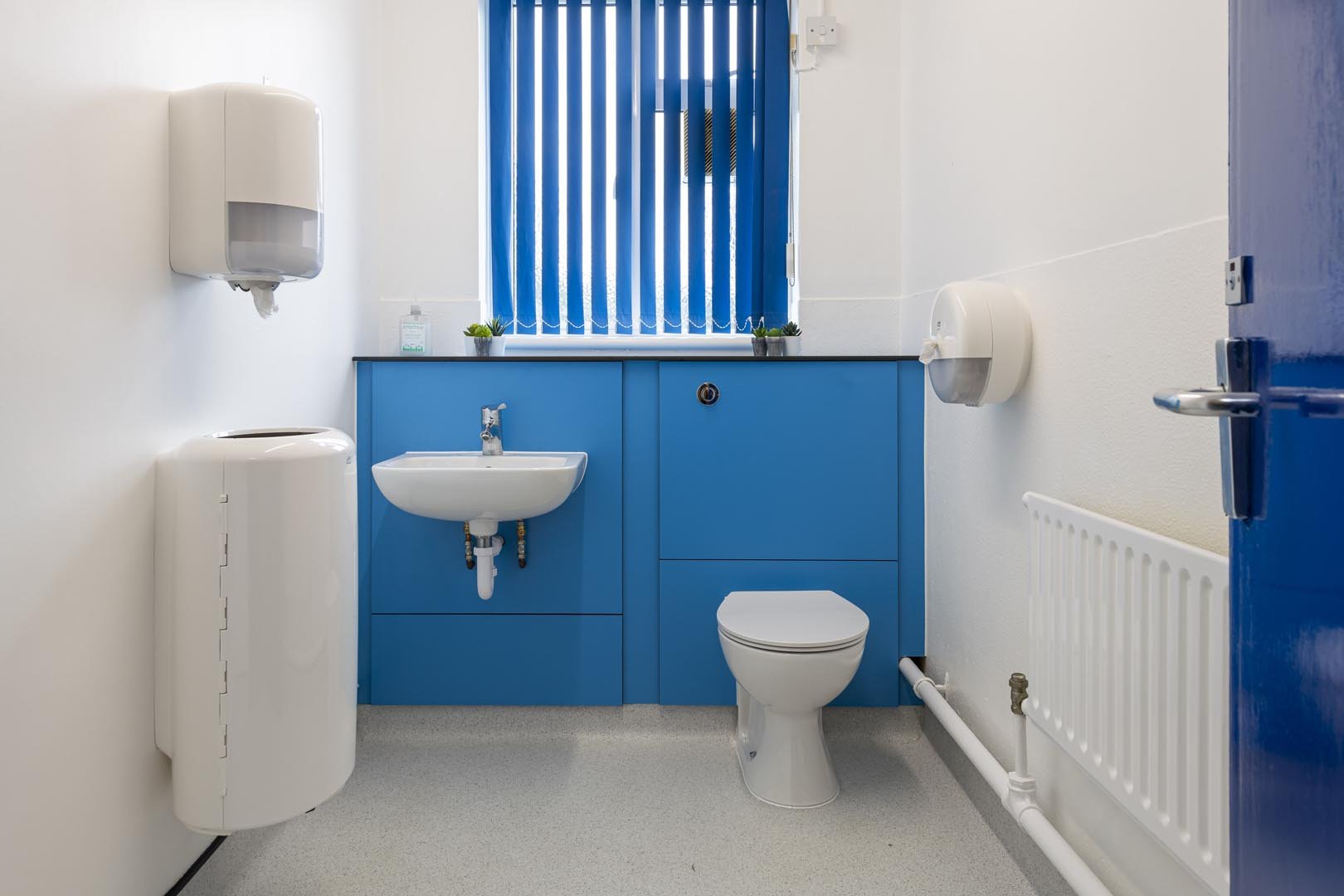 staff toilet and sink at howard junior school with blue low height duct panels and hygienic wall cladding.jpg