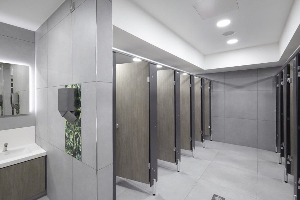 Row of grey woodgrain toilet cubicles in female toilet at shopping centre