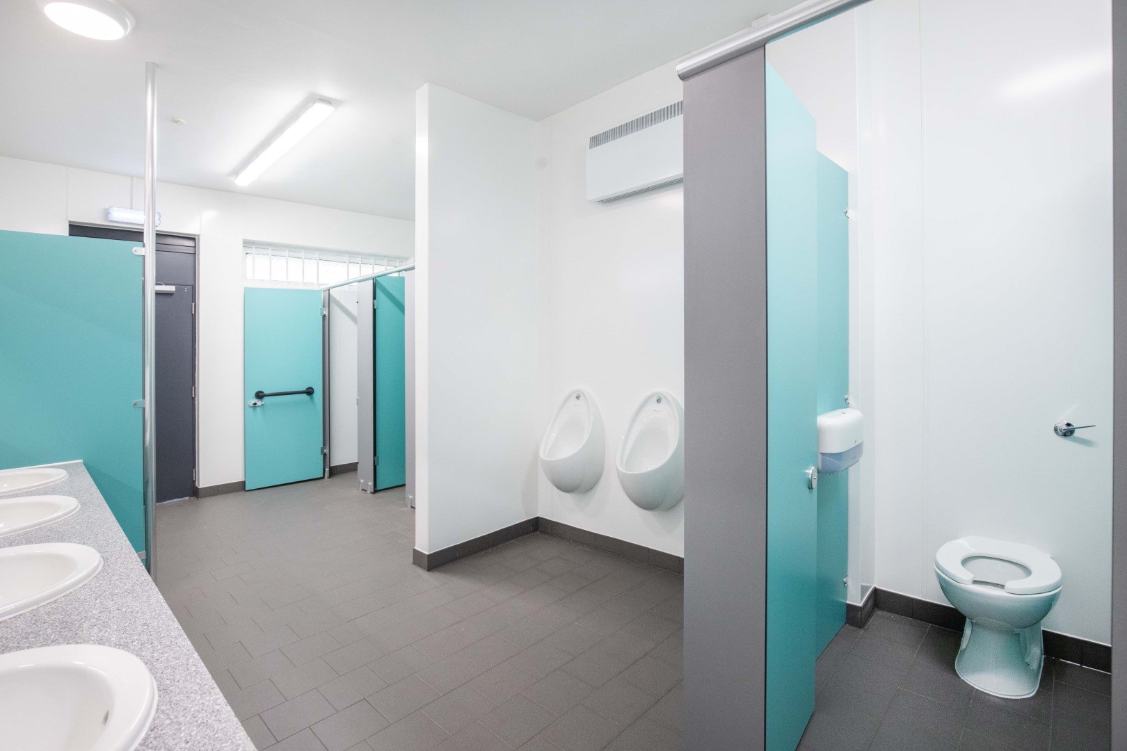 blue and grey washroom with urinals, showers and toilet cubicles at riverside campsite.jpg