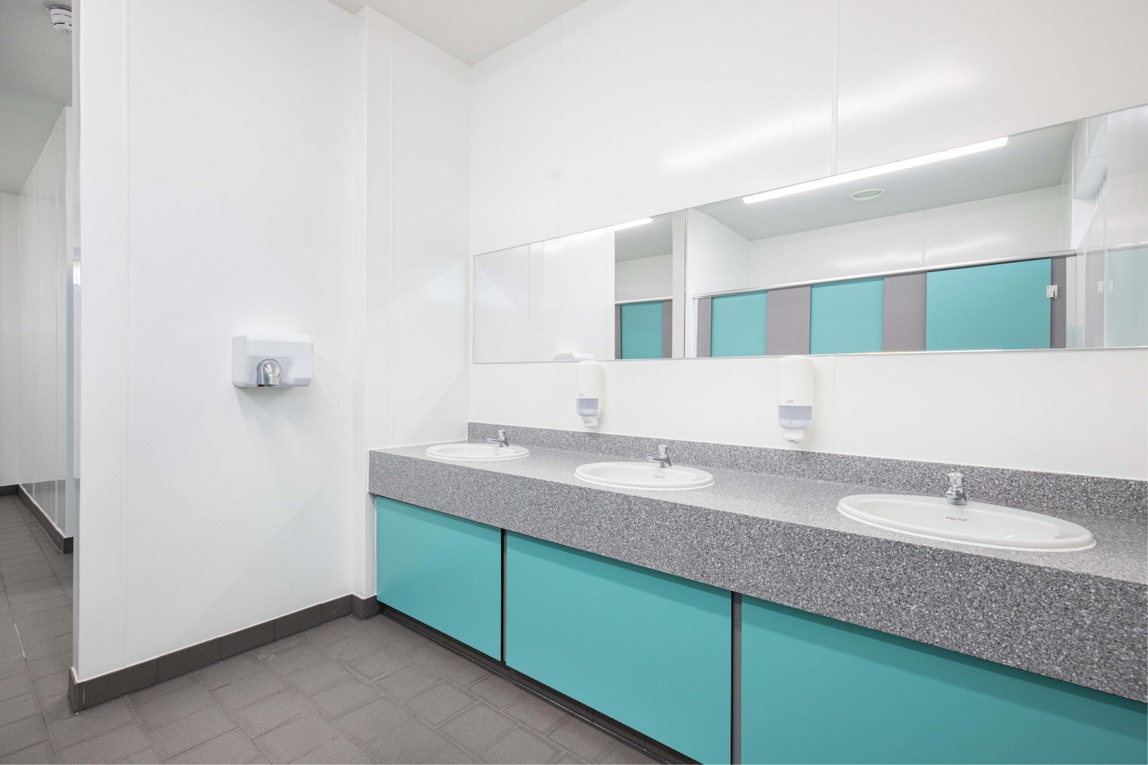 blue vanity unit with solid surface top and inset sinks in washroom at riverside campsite.jpg