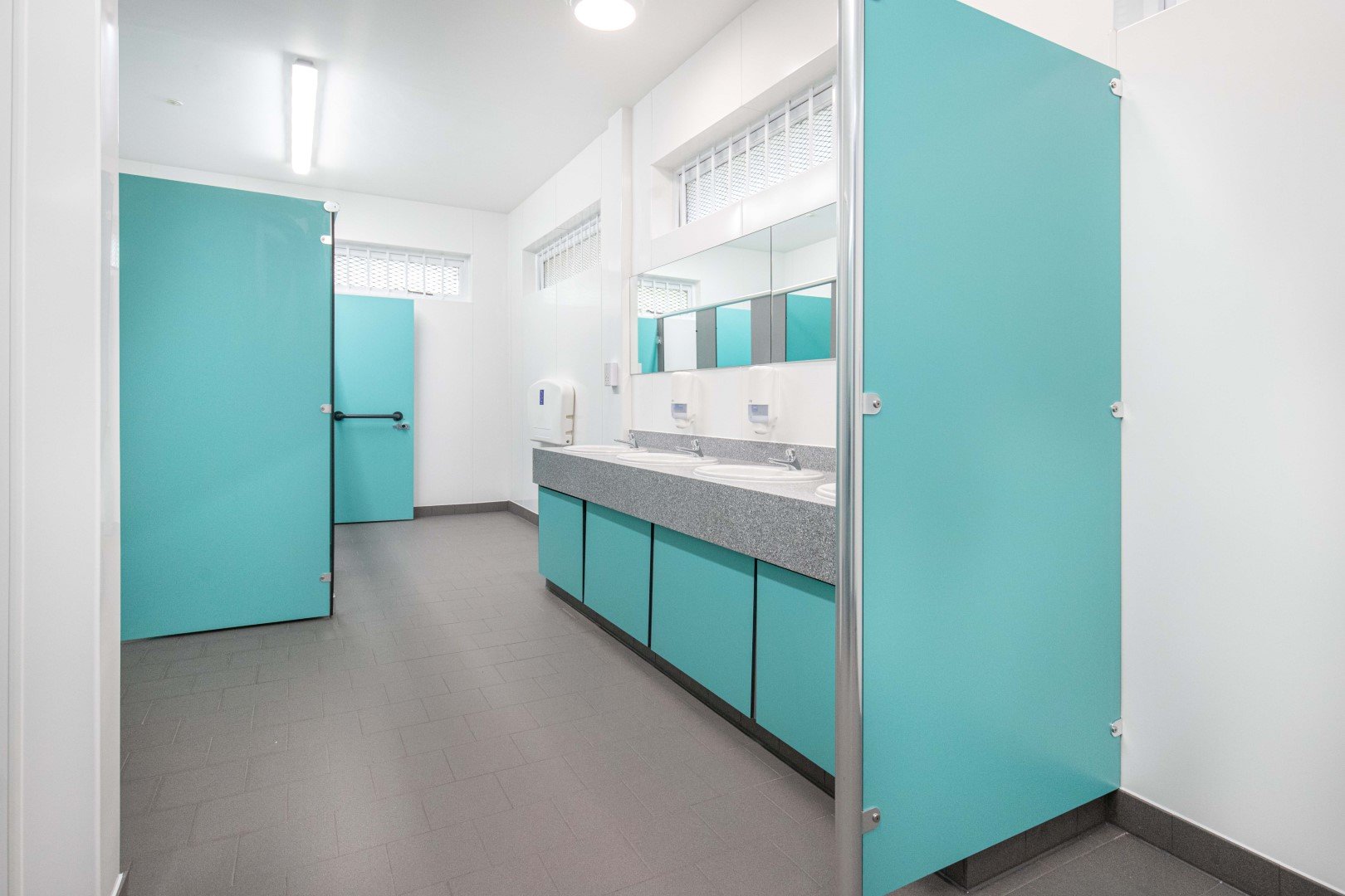 handwash area with blue vanity unit and solid surface top in washroom at riverside campsite.jpg