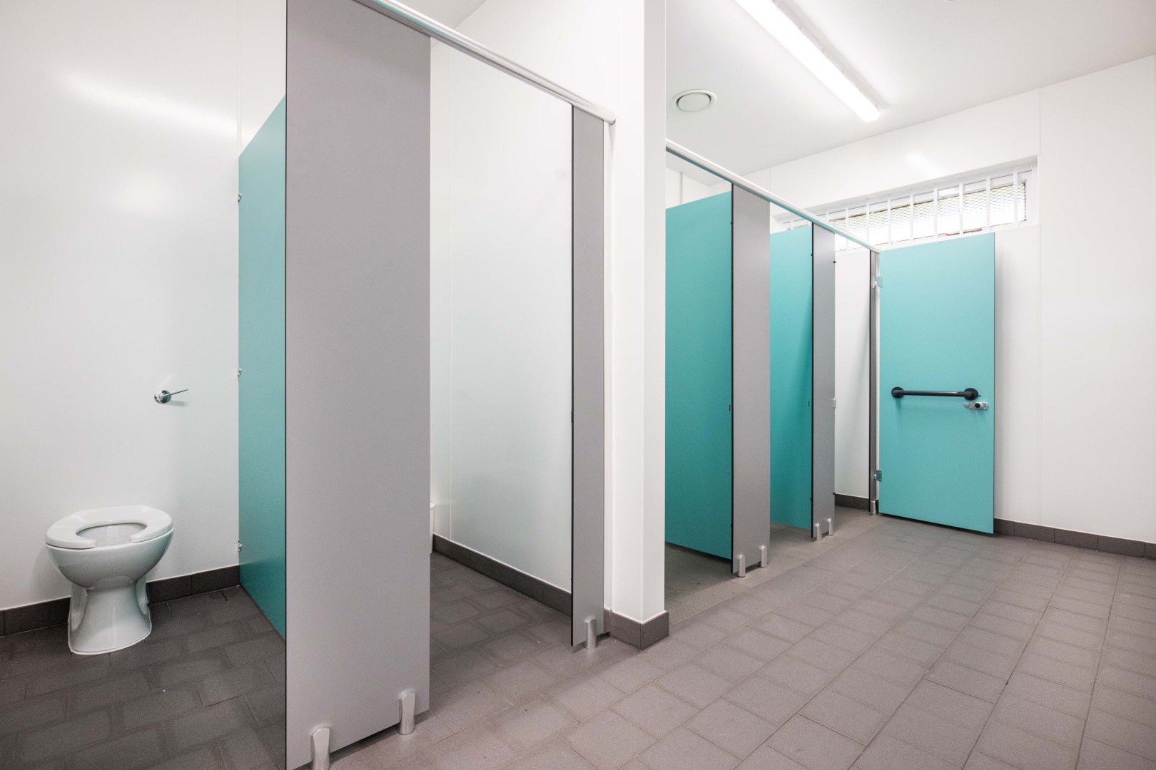 row of blue and grey toilet cubicles at riverside campsite.jpg