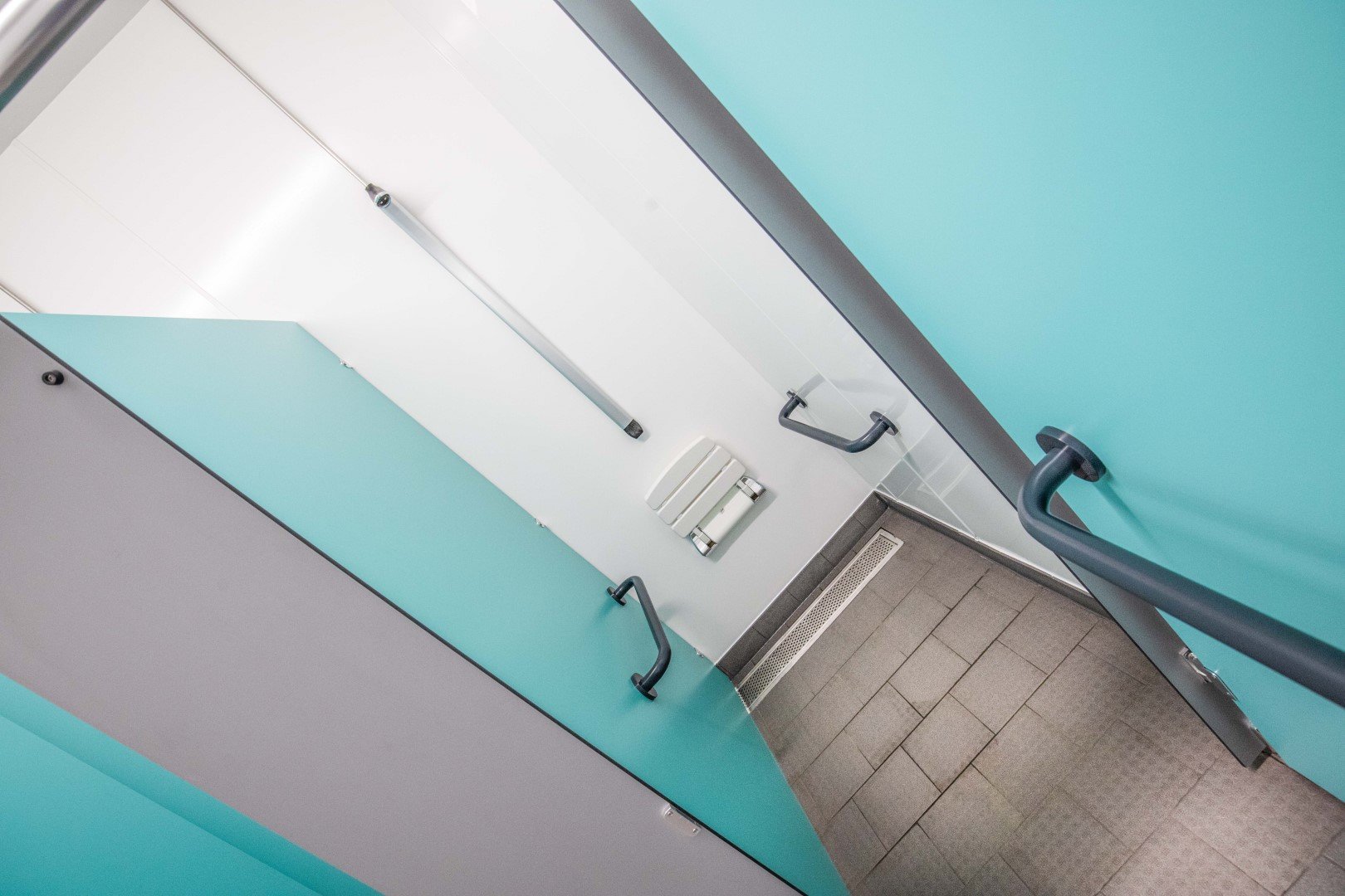 blue and grey shower cubicle with hygienic wall cladding at riverside campsite.jpg