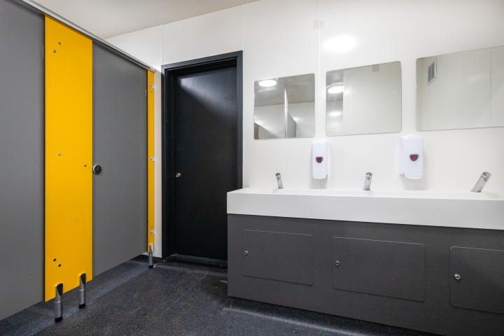 grey and yellow toilet cubicles and a grey hygipod ips vanity unit with solid surface trough at blyburgate public toilets.png