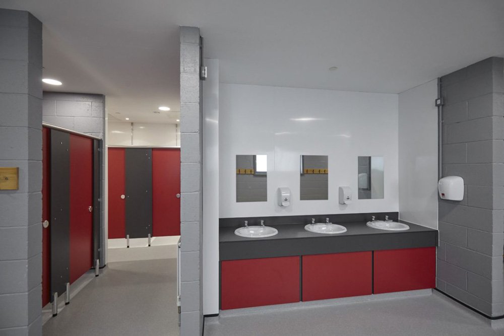 changing room cubicles and vanity unit with sinks at ark acton academy.jpg