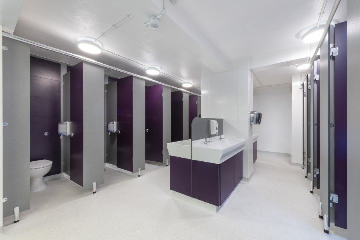 row of purple toilet cubicles and a communal hand wash vanity area at fakenham academy.jpg