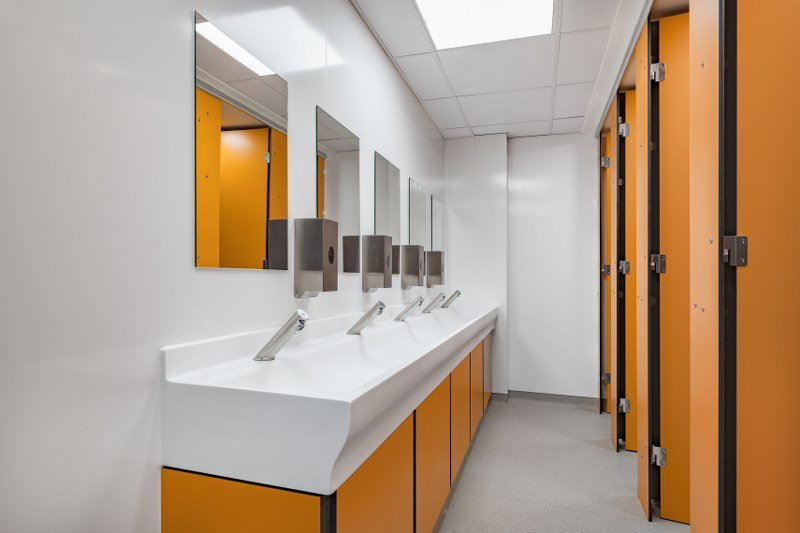 a school toilet block with orange colour scheme and privacy cubicles at ashcombe school.jpg