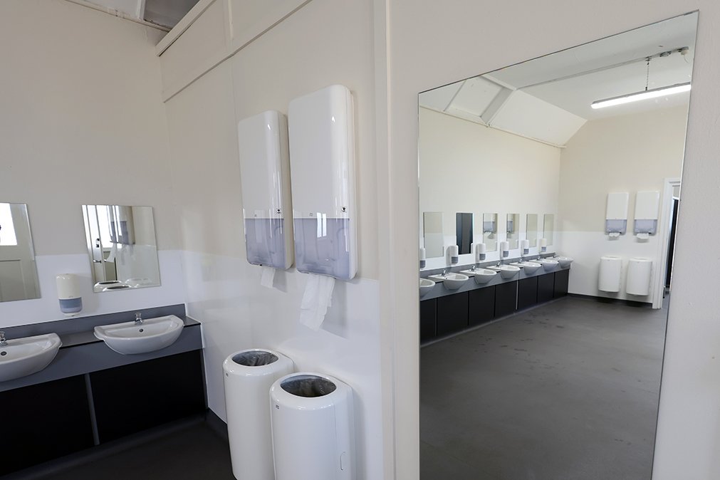 Full length mirror alongside paper towel dispensers and bins underneath with basins on the left at Ascot Racecouse.jpg