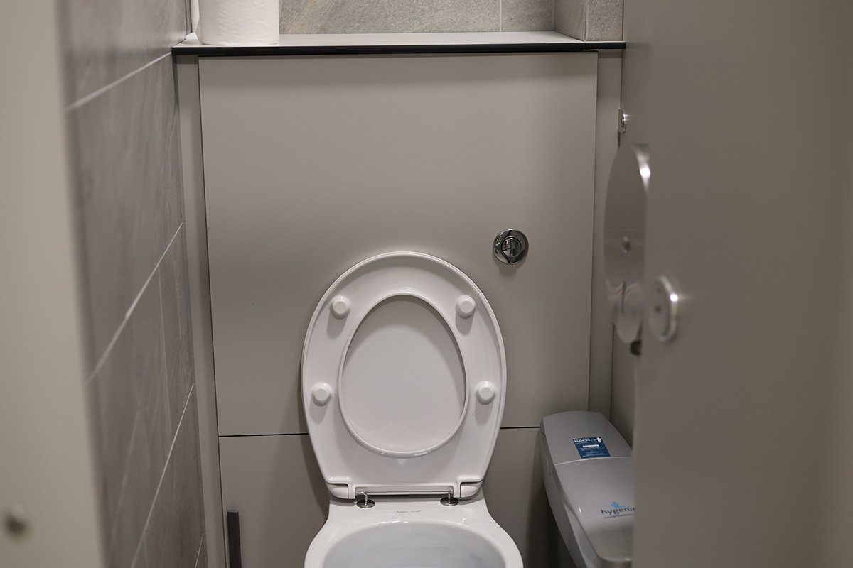 Toilet cubicle with duct panelling and push flush at golf club.jpg
