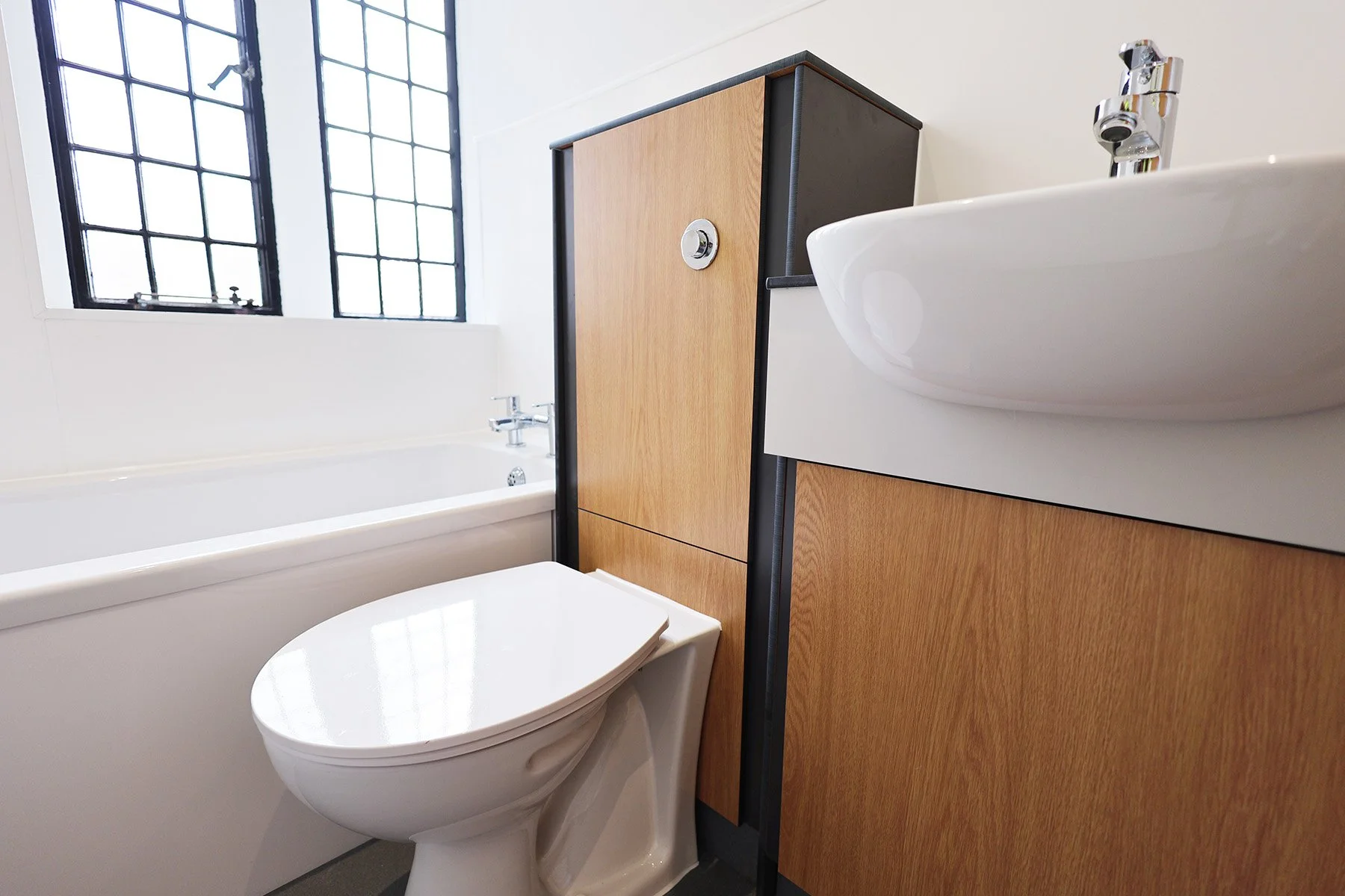 Close up of back to wall toilet with integrated basin at Lancing College.jpg