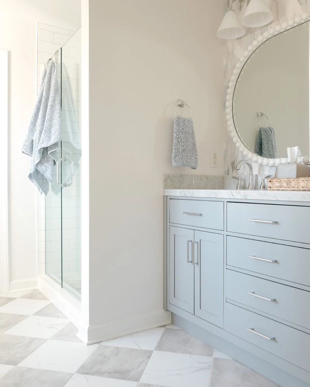 THE CLIENT REQUEST: "NO MORE BROWN!" What followed? A full primary bathroom transformation &mdash; custom vanity mirror, a gorgeous checkerboard floor, and soft coastal accents that feel like a deep breath by the water. Proof that the right