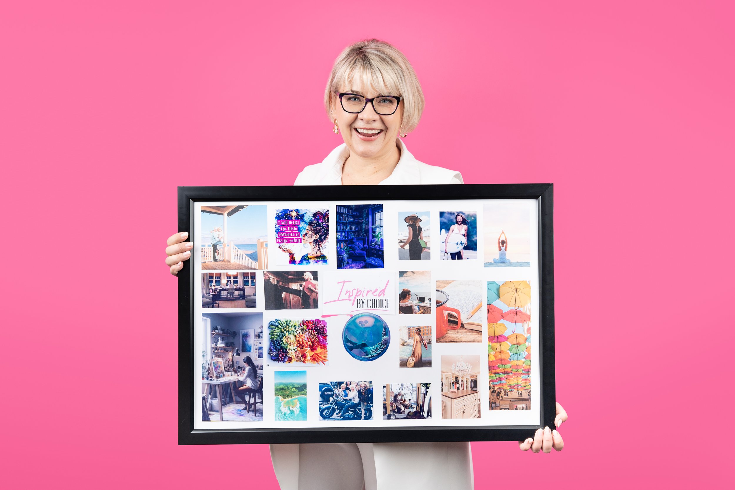 transformational coach Dorothy Bosse holds up her personal vision board, which includes a vibrant and intentional assortment of meaningful images and phrases that represent her vision for her business and her life