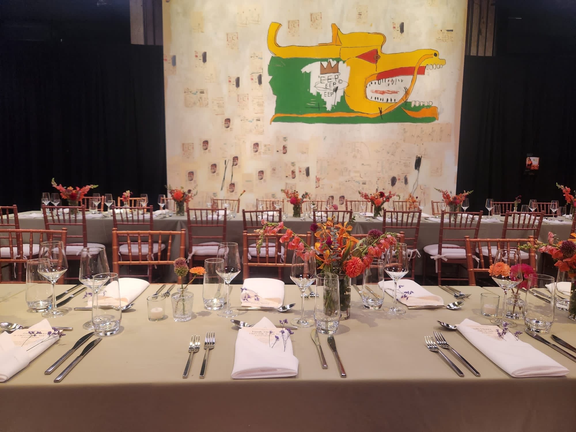 Two table setting with orange and pink floral arrangements