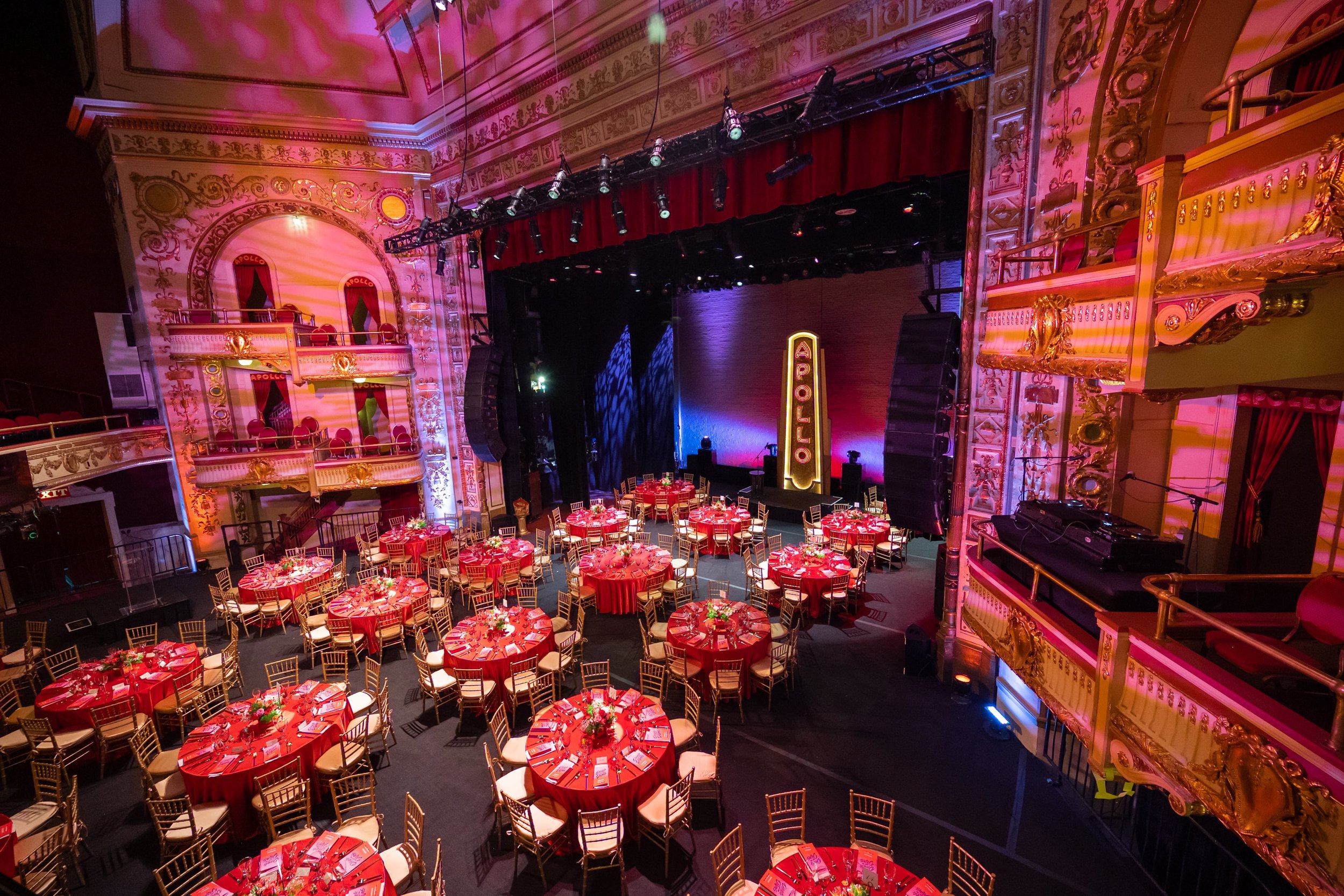 A birds eye view of the theater with round tables with floral arrangements