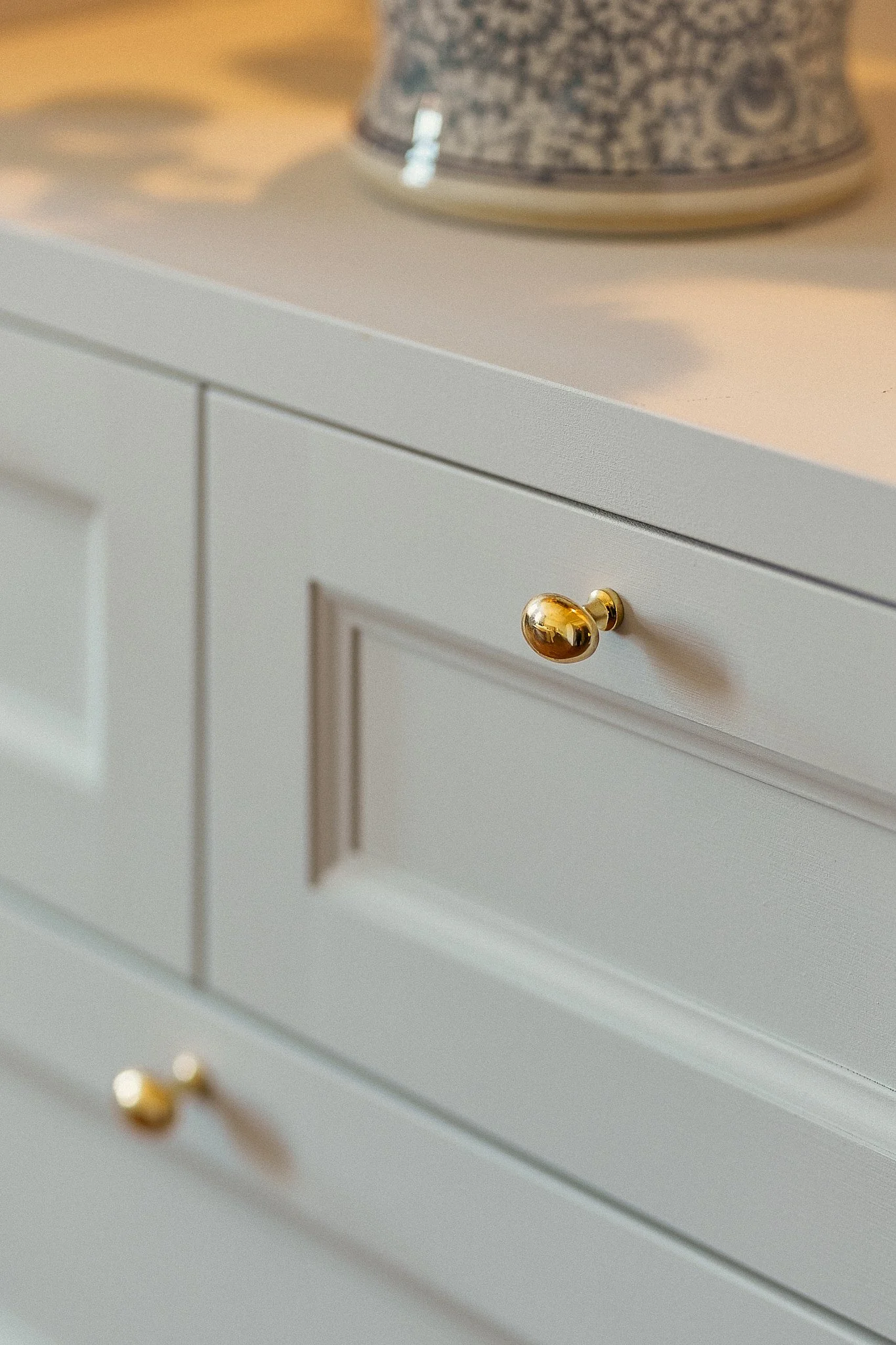 Detalj av platsbyggd garderob med mässingshandtag och spegeldörrar i klassisk sekelskiftesstil