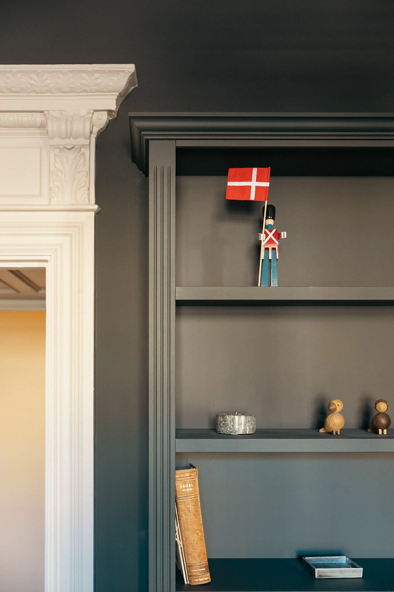 Detalj av platsbyggd bokhylla med klassiska snickeridetaljer i sekelskifteslägenhet