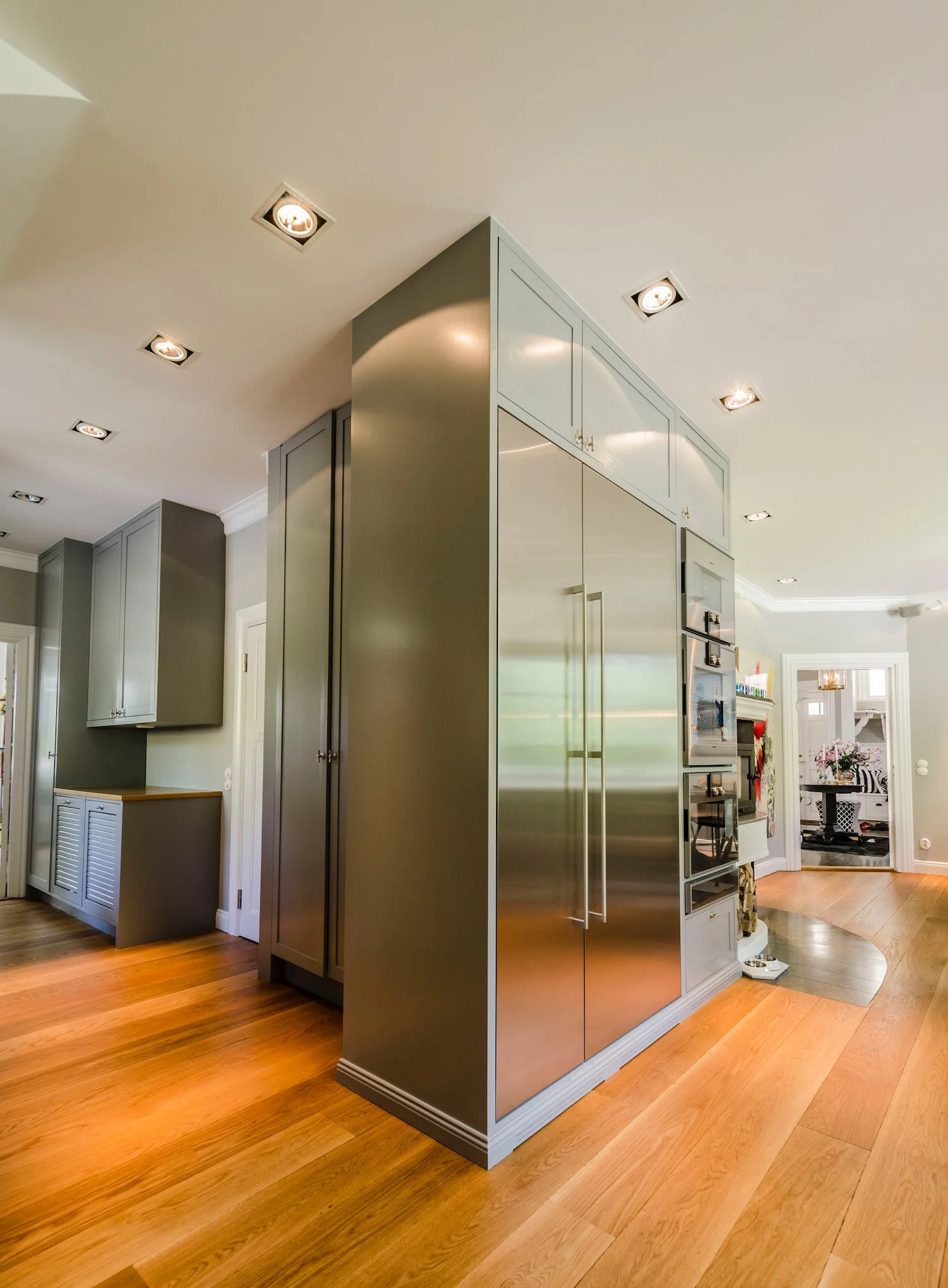 Platsbyggt kök med höga skåp och integrerad kyl i rostfritt i Danderyd.