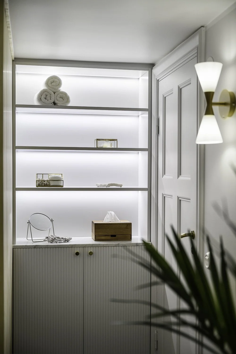 Platsbyggd förvaring med hyllor och integrerad belysning i klassisk stil i Stockholm