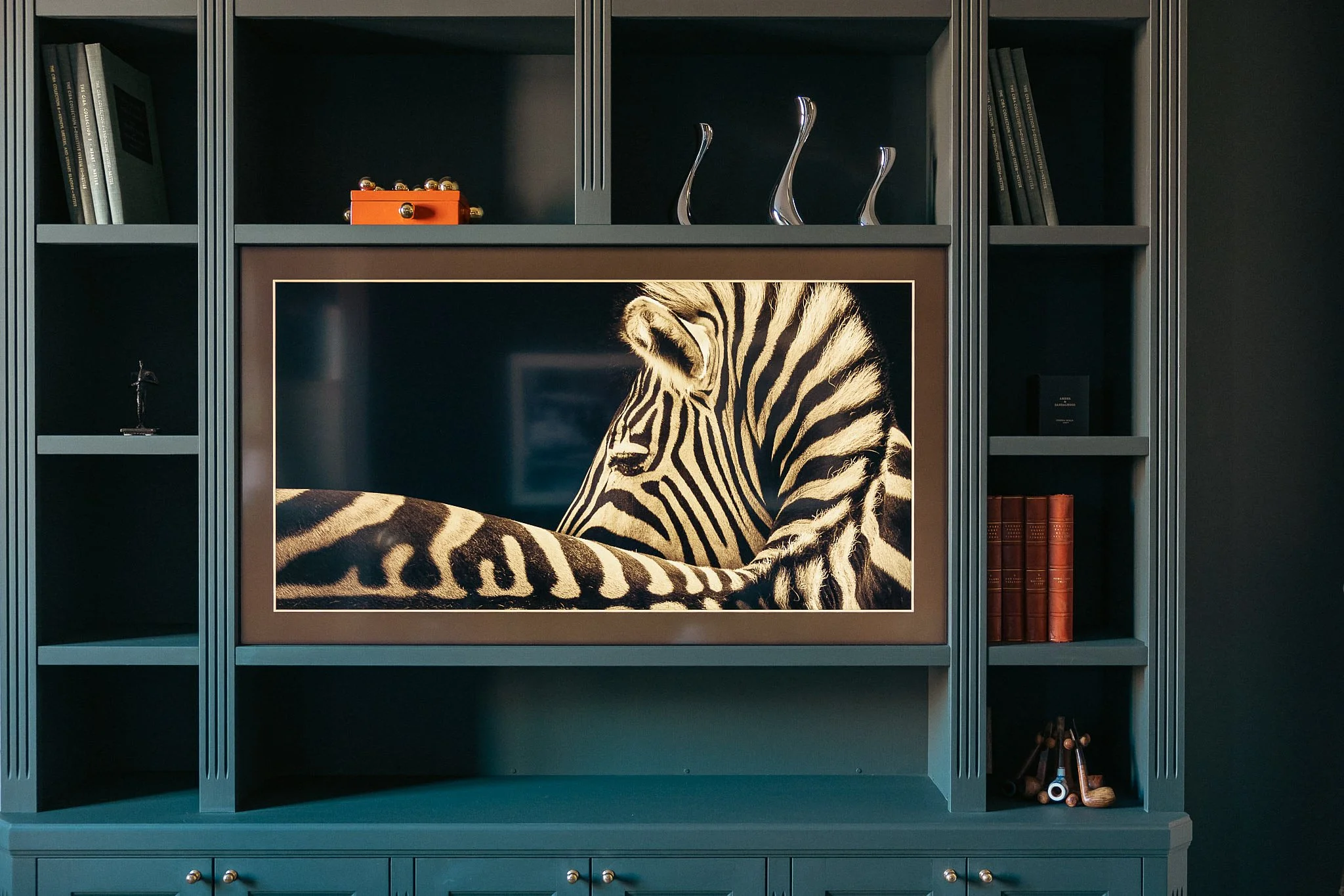 Platsbyggd bokhylla med integrerad TV och måttanpassad förvaring i sekelskifteslägenhet i Stockholm