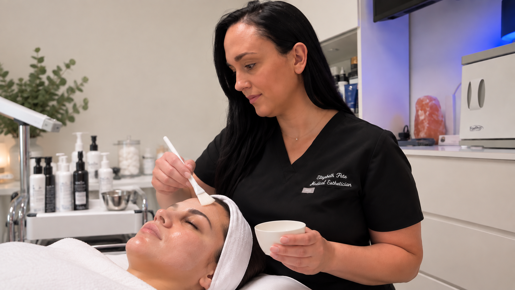 Esthetician performing a facial treatment at Firm Medical Spa in Tulsa