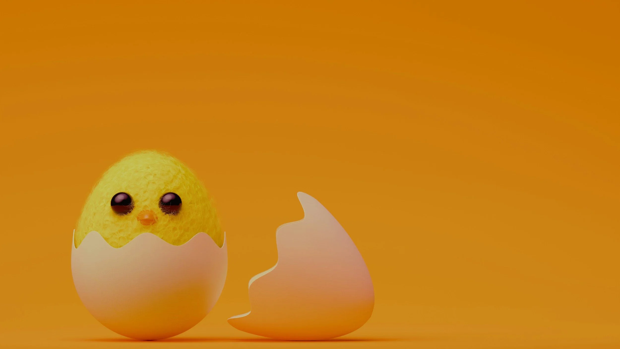 Image of a toy baby chick emerging from the shell after hatching.