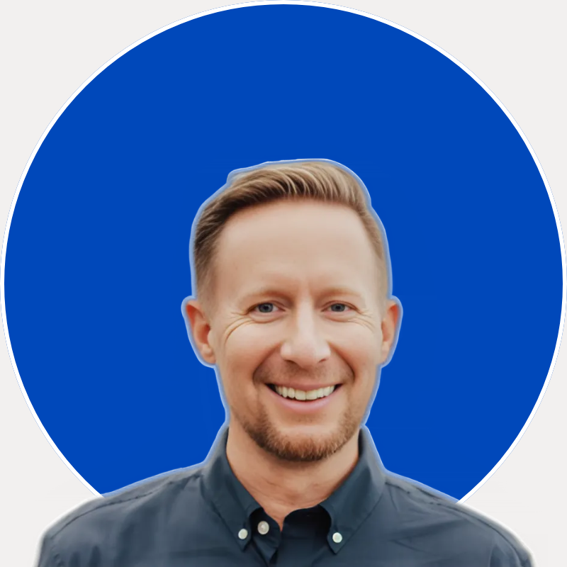 Headshot of Morgan Witt, Founder of witt+co. and San Diego Real Estate Advisor.  He has short blond hair, a light beard, and blue eyes, wearing a dark collared shirt against a solid blue circular background.