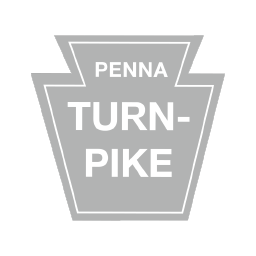 Pennsylvania Turnpike sign in gray, with the text "PENNA TURNPIKE."