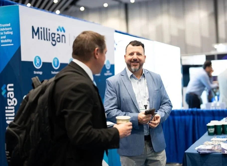 Dave DiAngelo smiling with a colleague at the Milligan IBTTA booth
