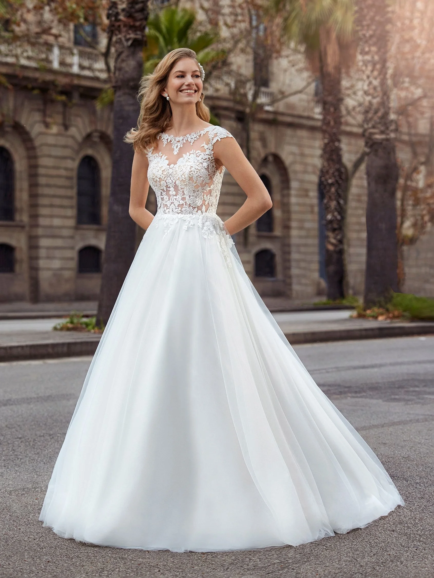 White One Daze off white/nude A-line wedding dress with lace bodice, floral appliqués and flowing tulle skirt with illusion back, bridal sample size 16, available at Olive and Ivory in Sacramento