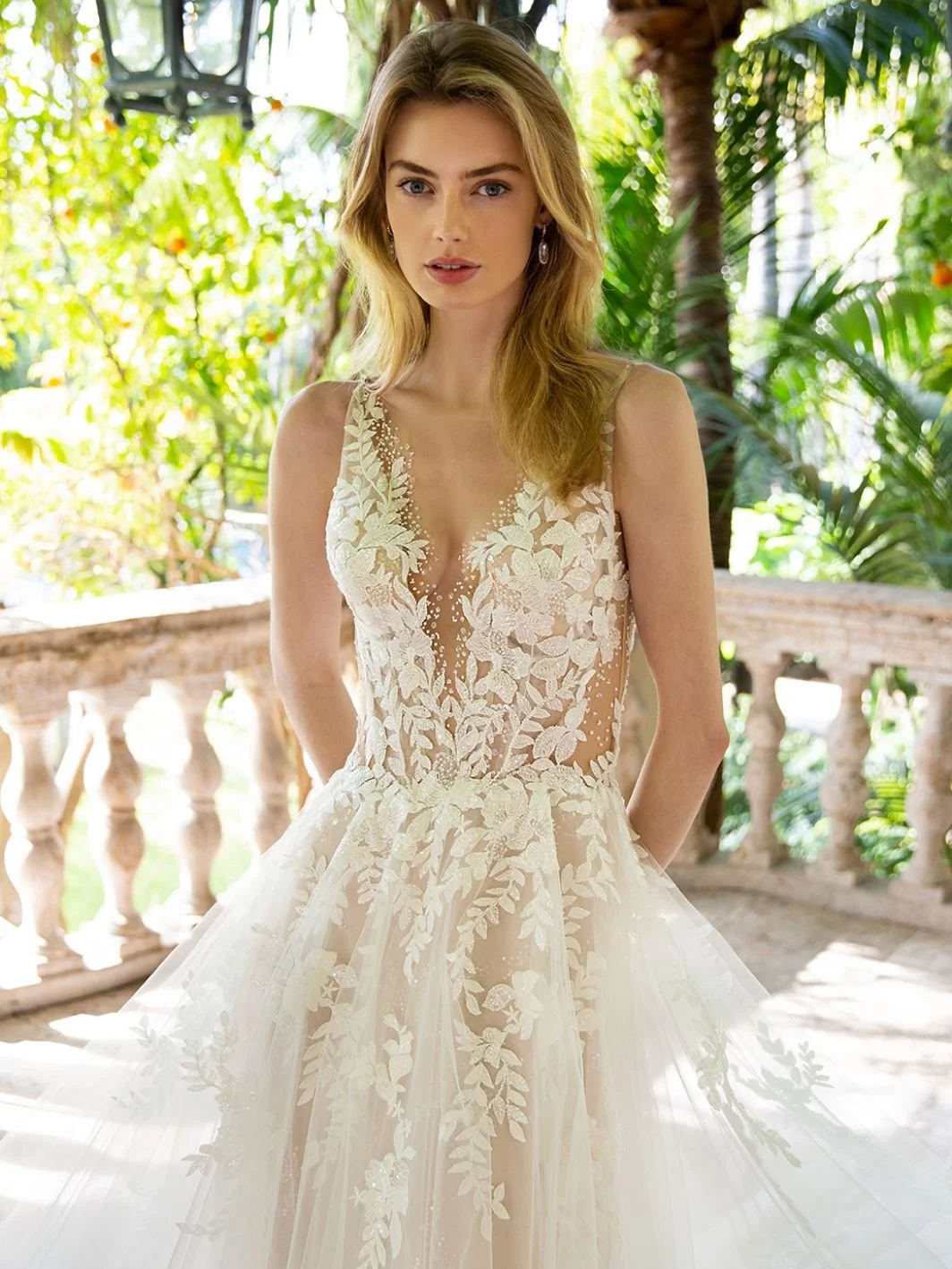 Enzoani Riva A-line wedding dress with plunging V-neck illusion bodice, beaded floral lace, sequin tulle layers, and open back