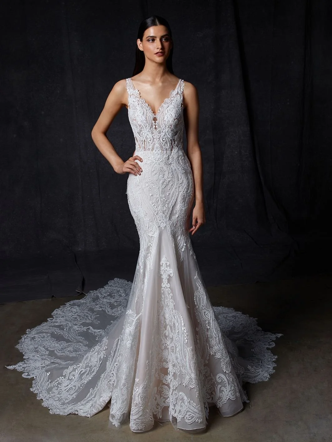 Enzoani Orsa romantic lace mermaid wedding dress with plunging V-neckline, laser cut baroque lace, and illusion front panel
