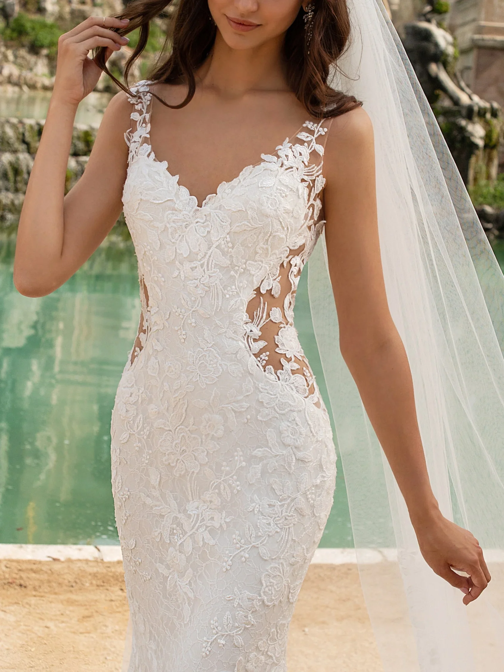 Pronovias Morocco lace trumpet wedding dress with deep V-neckline, illusion waist panels, and crystal accents