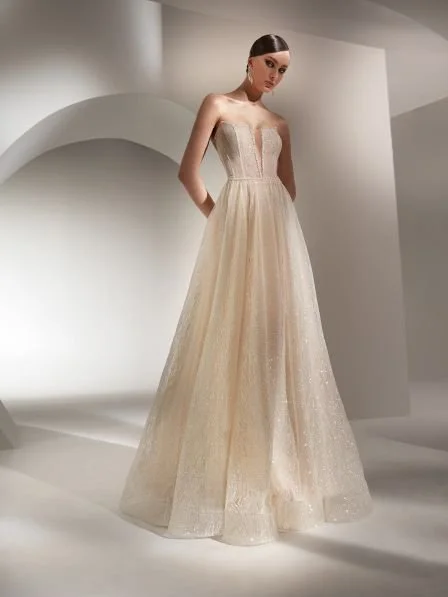 Nicole Spose Jinan A-line wedding dress with glitter tulle, strapless sweetheart neckline, illusion plunge, corset bodice, lace-up open back, and chapel train at Olive & Ivory Bride.