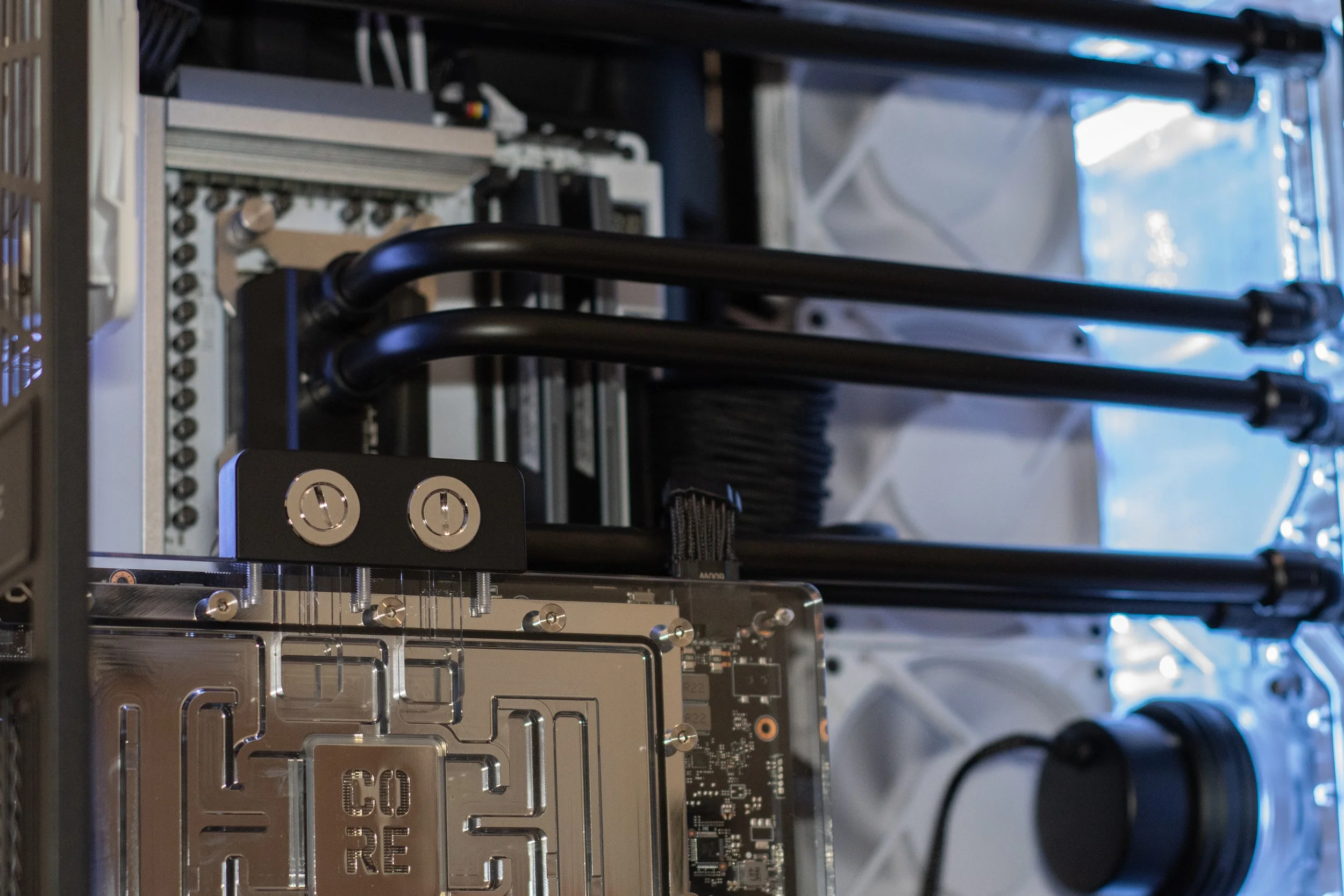 Close-up view of a computer's internal components, including cooling pipes, a circuit board, and other hardware inside a custom-built PC.