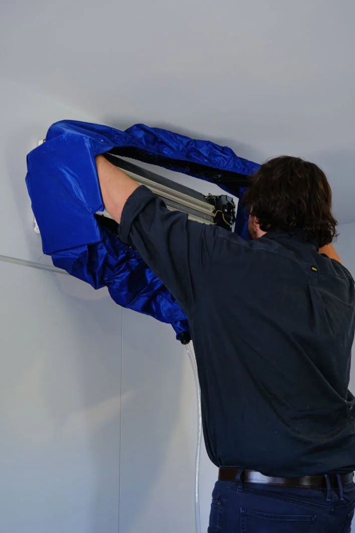 A dedicated technician in East Brisbane meticulously cleaning an air conditioning unit. Dive into a cooler summer with our premium AC maintenance services right in the heart of East Brisbane.
