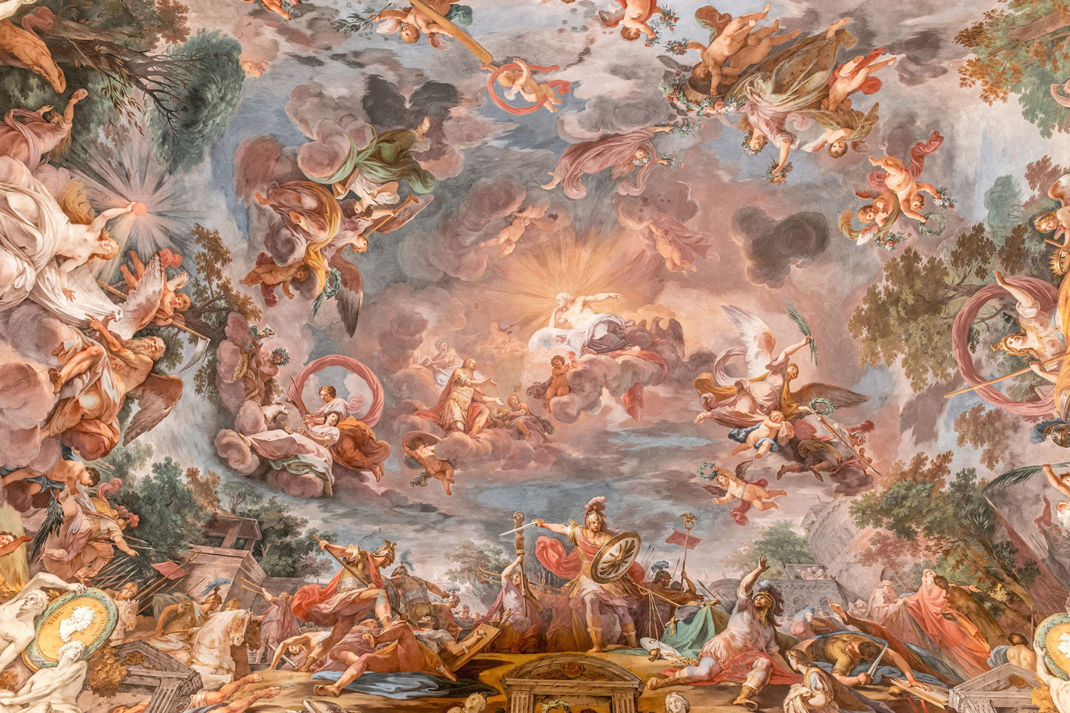 A detailed Baroque-style ceiling fresco illustrating mythological and divine scenes with numerous figures, clouds, and a radiant central deity figure surrounded by angels and gods.