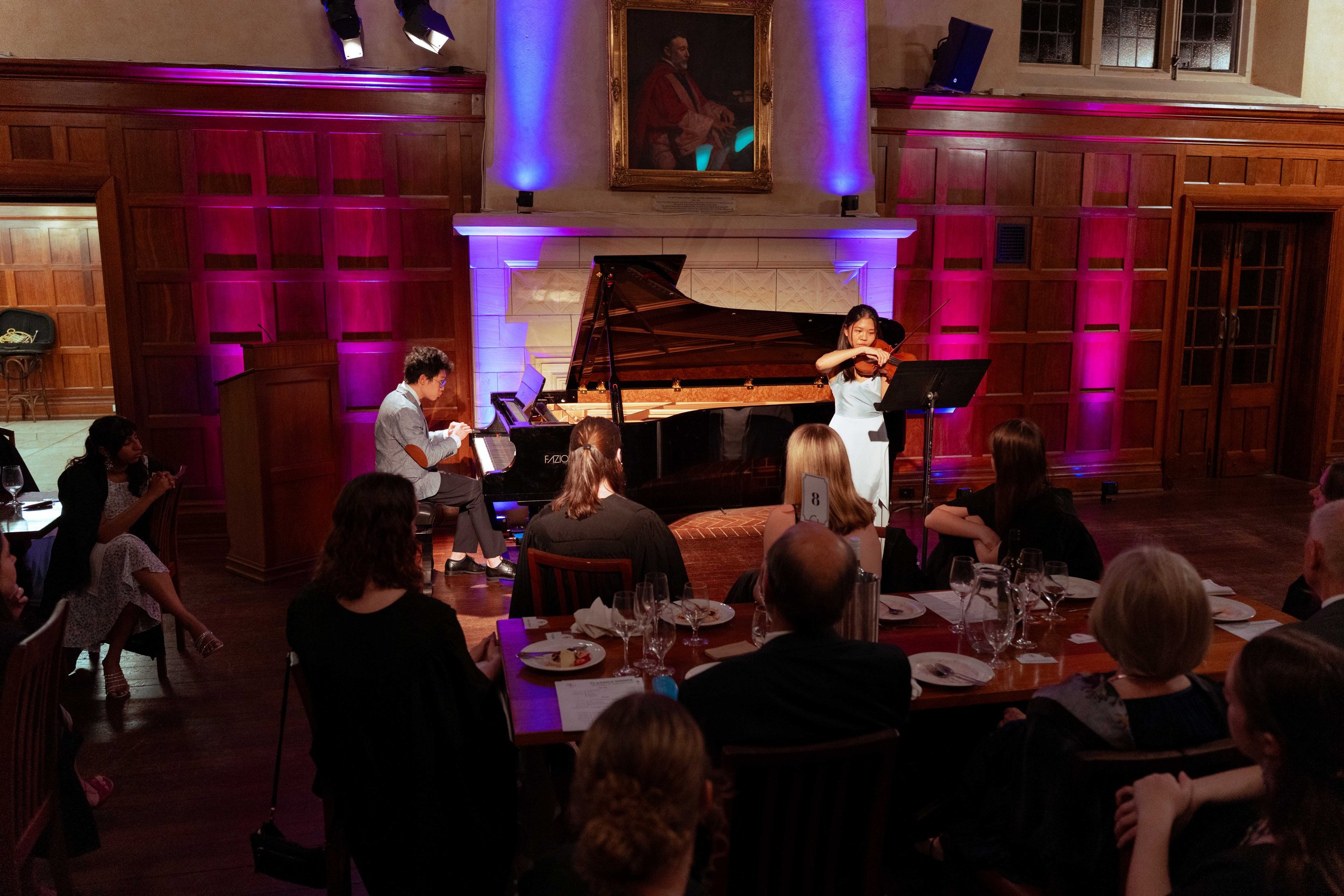 Titus Tan at the Piano and Jeanette Tham on Violin perform to an audience in the Dining Hall at St George's College.