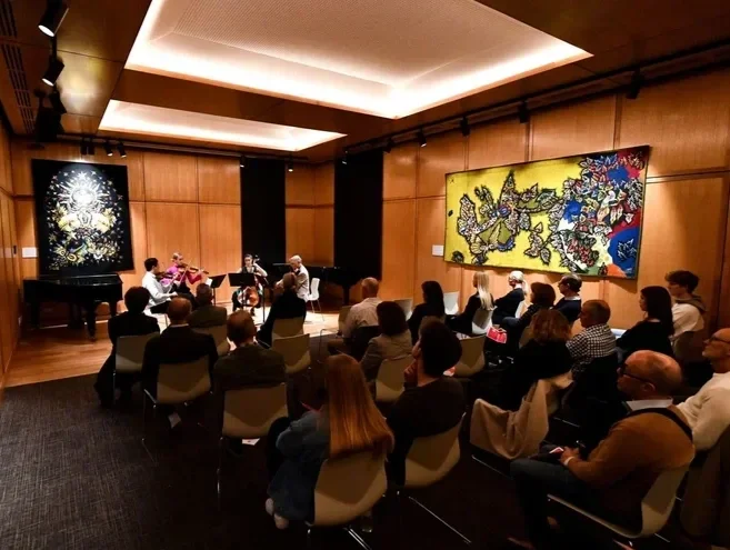 An audience is seated in the Ruth Rodgers Room at St George's College.