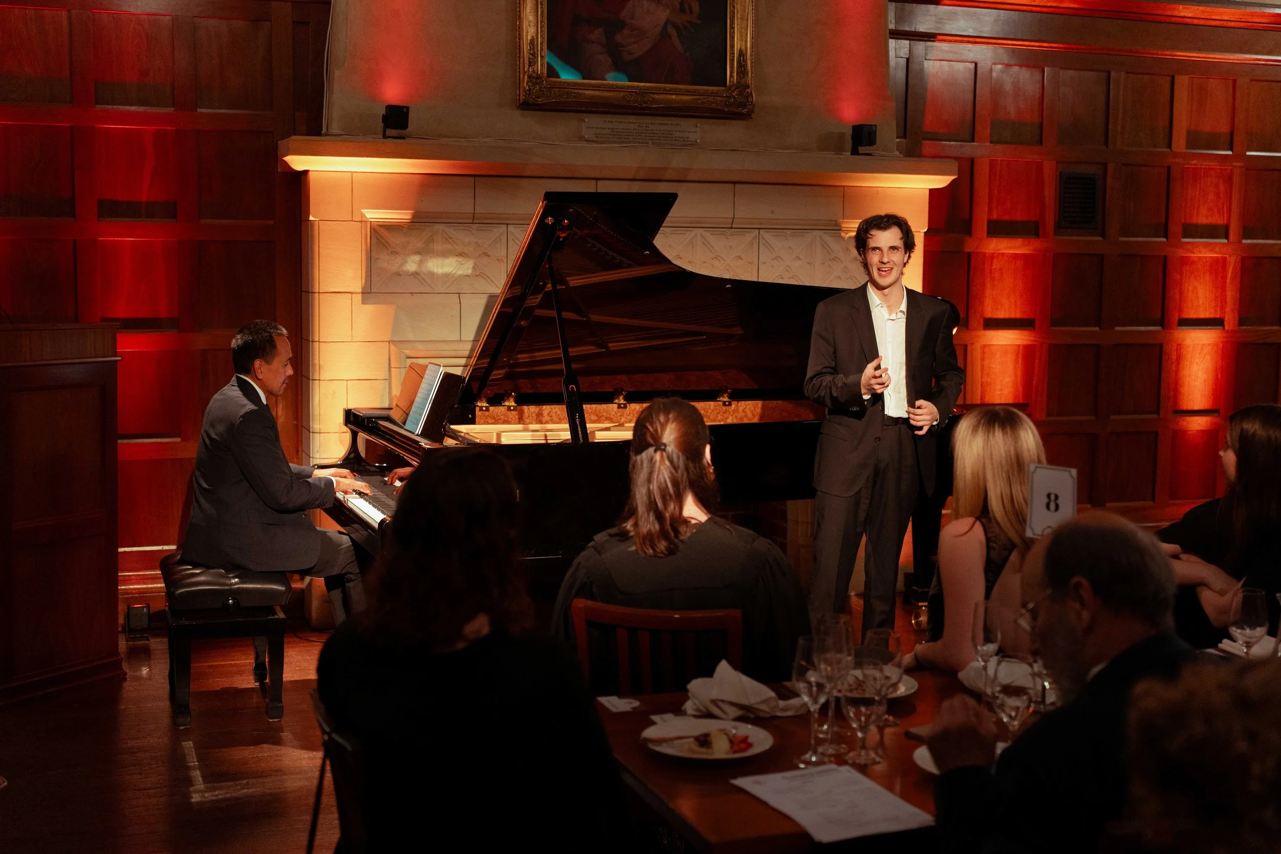 Raymond Yong and Ilario Sellitto perform in front the fireplace and panelling of the Dining Hall at St George's College.