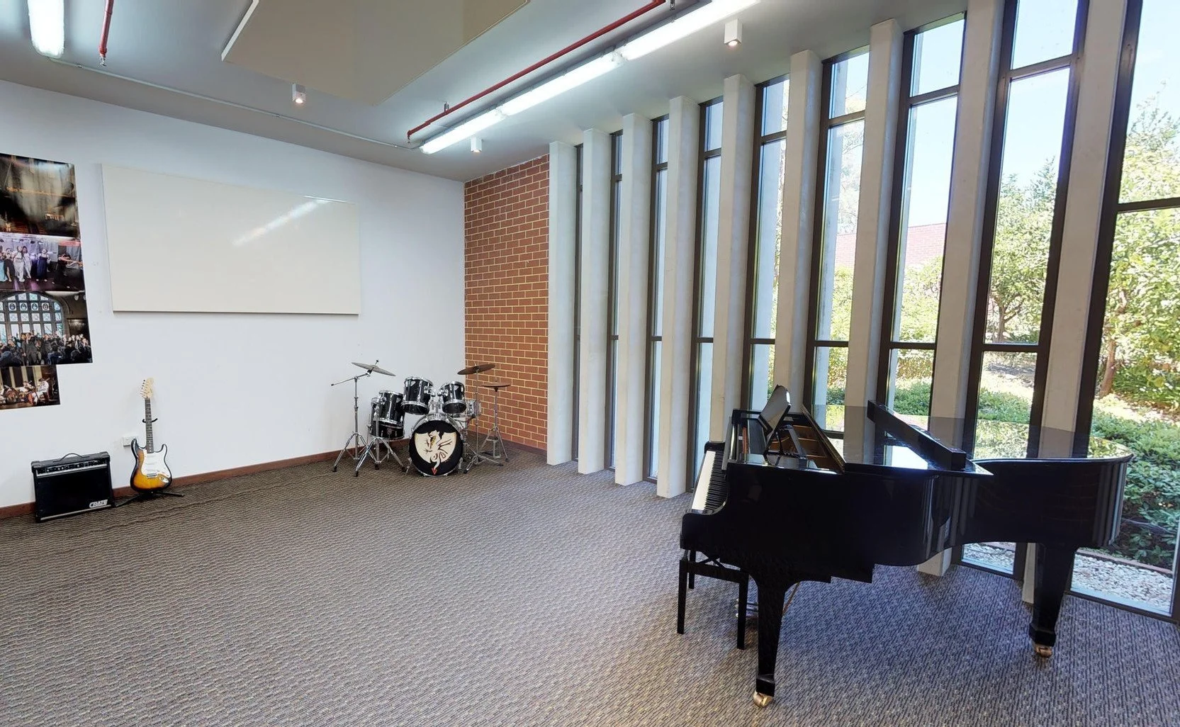 A baby grand, drumkit, guitar and amp in the resident music room at St George's College.