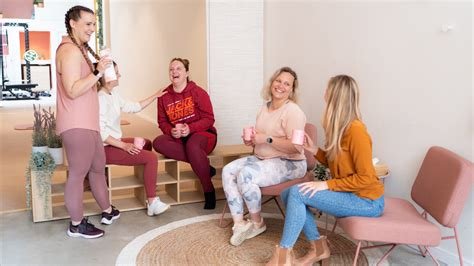 Teamleden van Bibi fitstudio en Adem Je Fit! lachen samen; een community van vrouwen die elkaar helpen bij het beheersen van angst en stress tijdens het sporten.