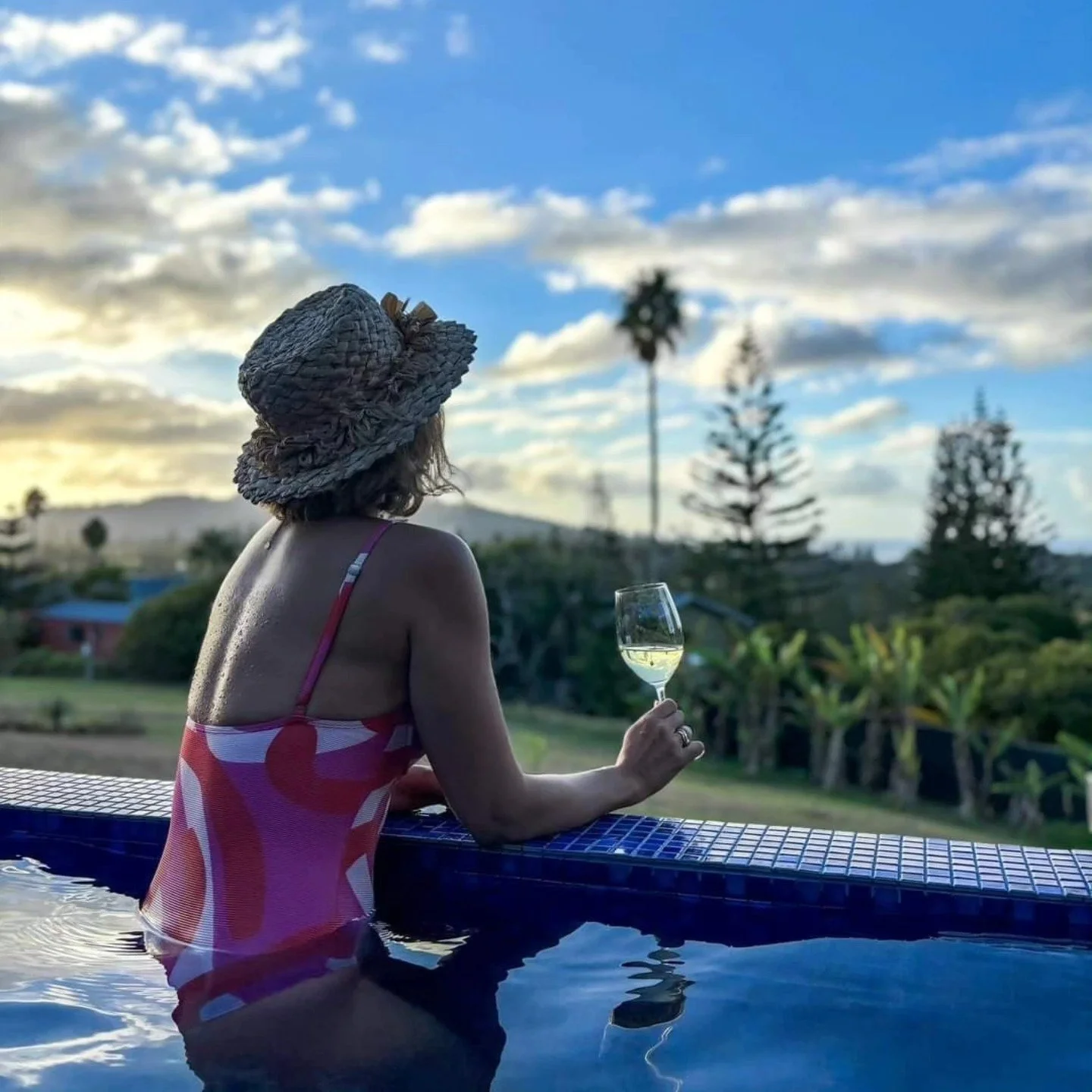 Woman stranding in pool with wine glass