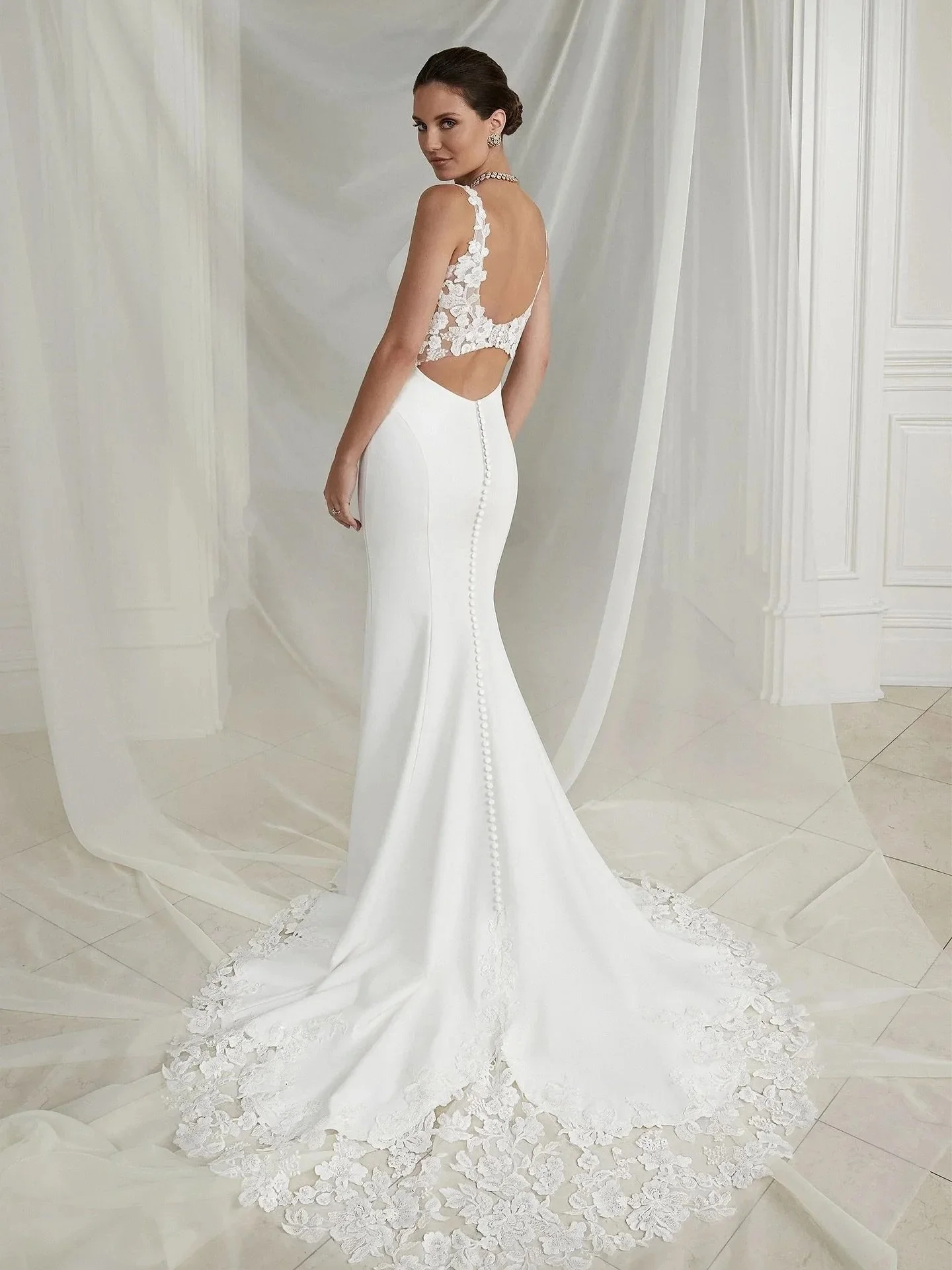 ✨ Size 6/8 ✨

A beautiful crepe, fitted style with a V neckline. But it&rsquo;s all about the back, with a lace cut out, buttons the length of the train and a statement lace cut out train!!!!

Designer - Justin Alexander