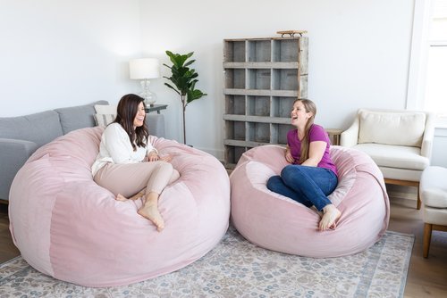 Lifestyle of two women sitting on Velvet Peony Havens laughing.