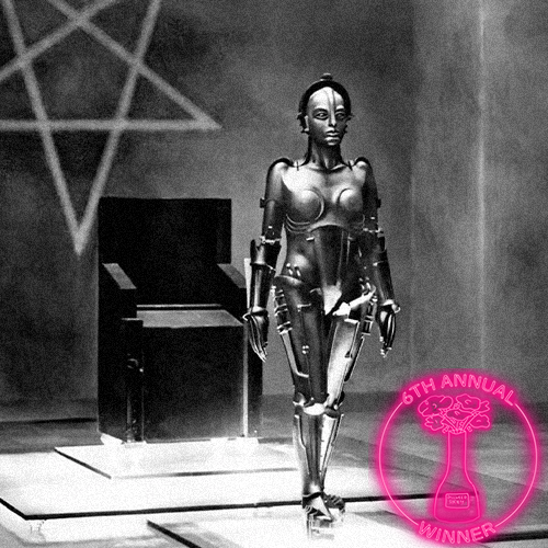 A woman with blonde hair holding a black telephone receiver near her face, looking to the side. She is wearing a necklace and has a soft, neutral makeup look. There is a badge in the bottom right corner that reads 'The 5th Annual Dillweed Society Excellence in Film Awards Winner.'