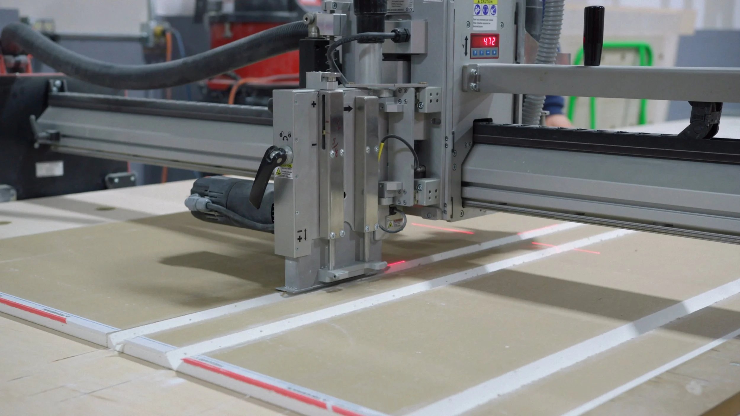 A drywall cutting machine used to create intricate and precise forms on a panel of drywall for prefabrication uses.